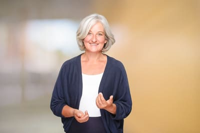 Portrait einer Mitarbeiterin vor einheitlichem Hintergrund